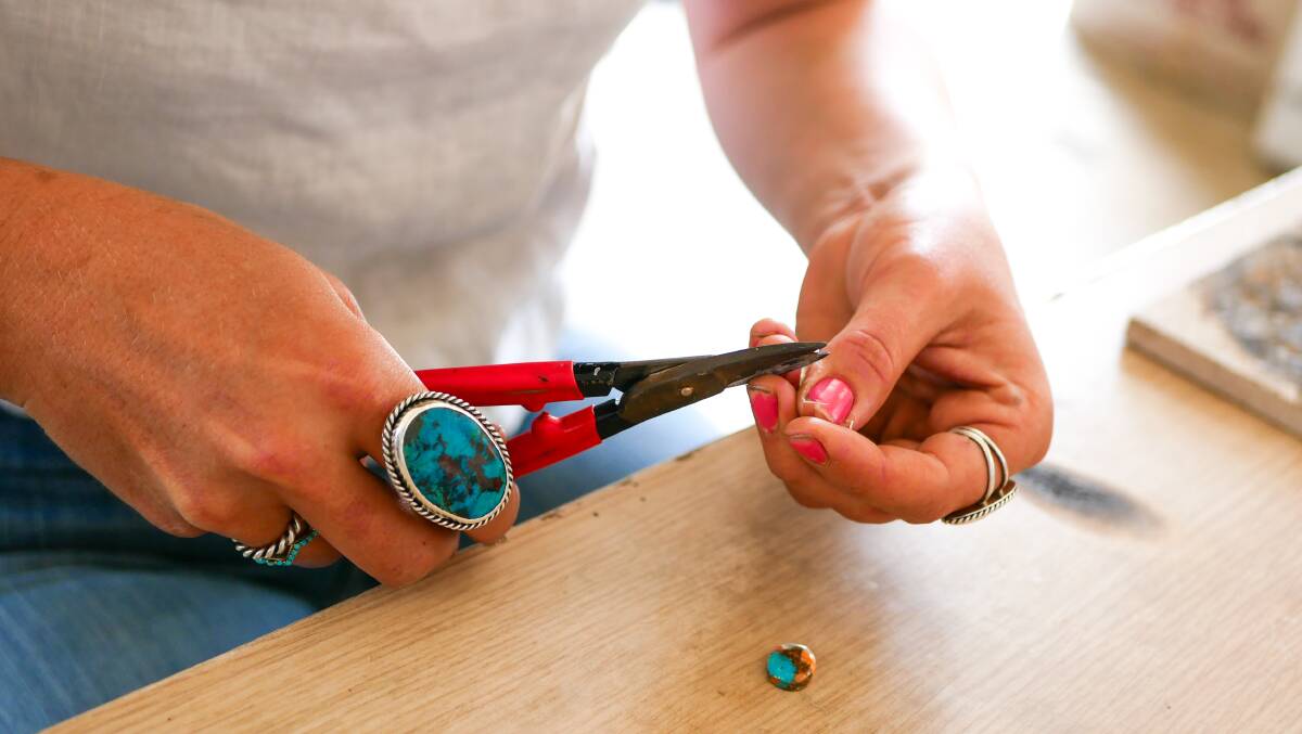 Remy uses pliers to cut and bend the silver into the correct size to fit around one of the unique stones she purchased from a mine in Arizona. Picture by Ellouise Bailey 