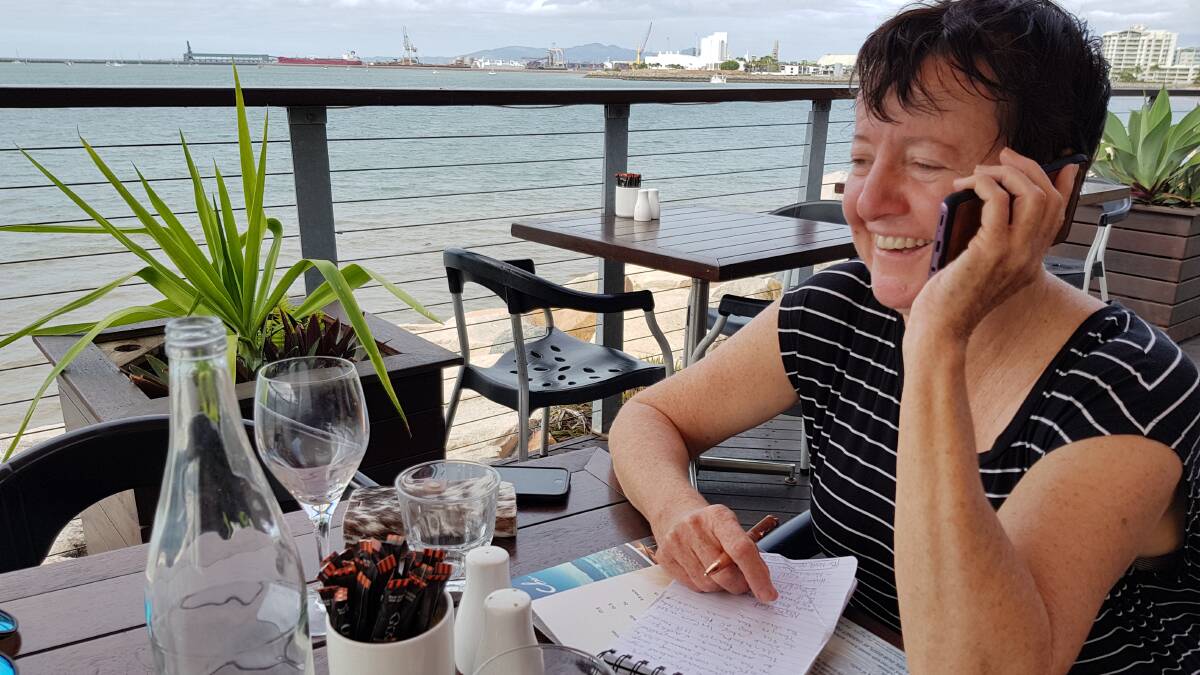 Still on the job while out to lunch in Townsville, this time with a mobile phone. Picture: Fiona Lake
