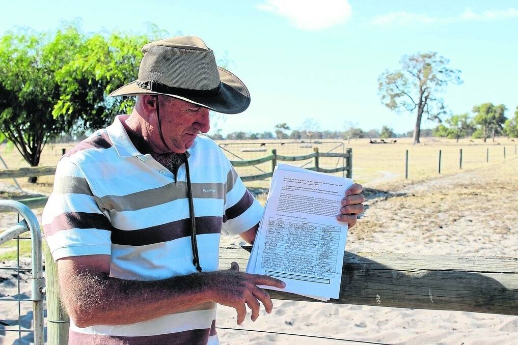 Waroona resident Raymond Hull with some of the signed pages of the petition.