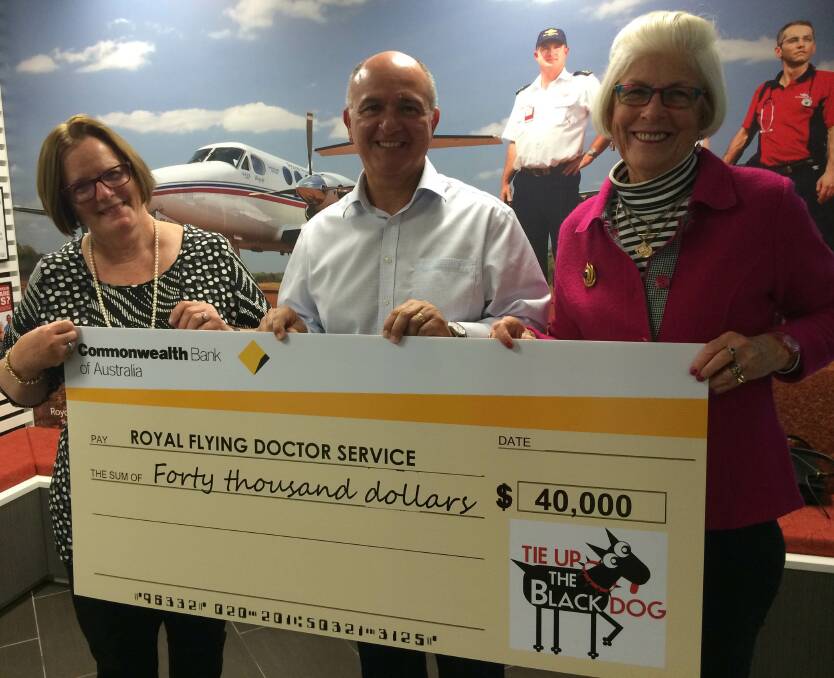 RFDS chief executive officer Nino Di Marco receives a cheque for $40,000 from Mary Woods and Liz Wood from Tie Up The Black Dog.